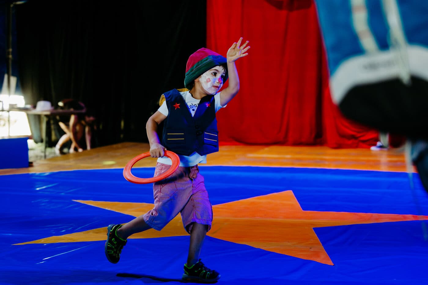 Kleiner Clown mit Ringen in der Manege